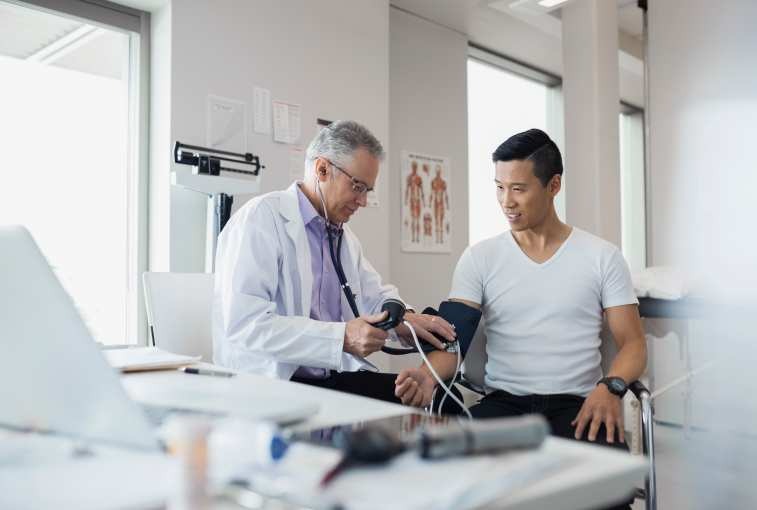 preventive screenings: doctor taking patient's blood pressure