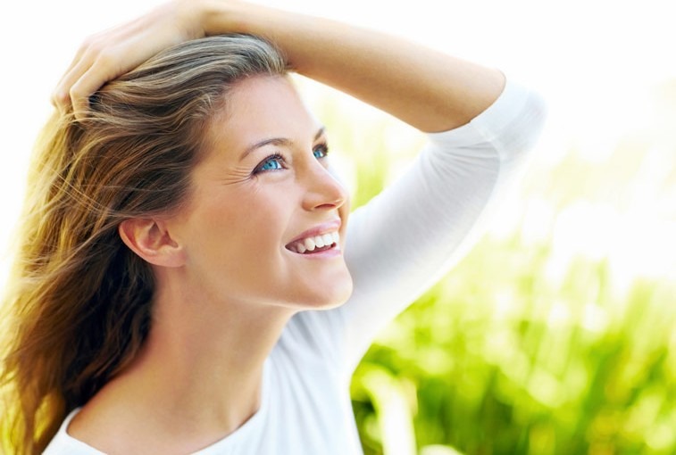 Young female smiling with hand on head