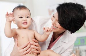 doctor smiling and holding baby