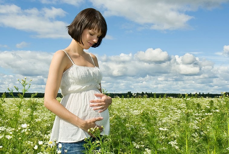 pregnant woman standing in field