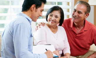 advance directives: young man helping older couple arrange legal documents