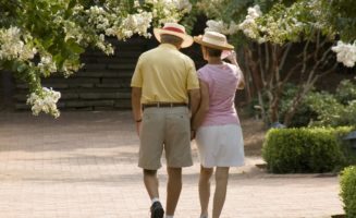 older adult couple walking through flowering trees