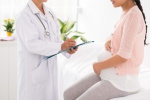 pregnant woman talking to a doctor