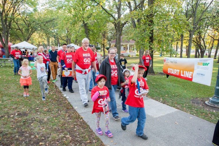 People dressed in red walk down the sidewalk in the 2017 Fargo Heart Walk
