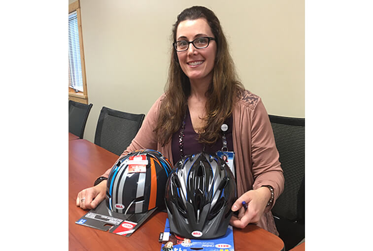 LynMaree Harris, the trauma program manager and coordinator for Sanford Health in Northern Minnesota, displays helmets from the Brain Bucket campaign.