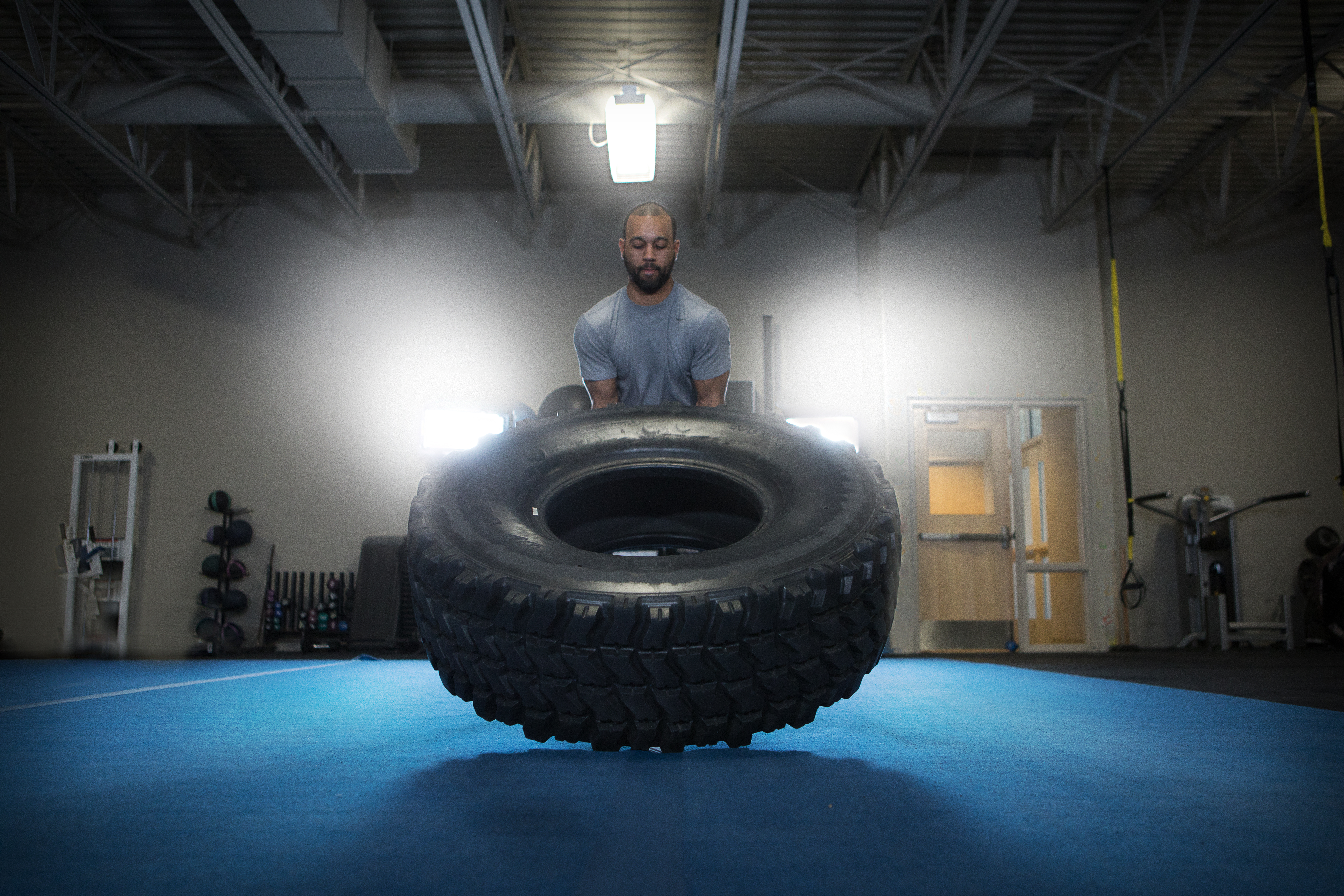 Male lifting a tractor tire at the wellness center