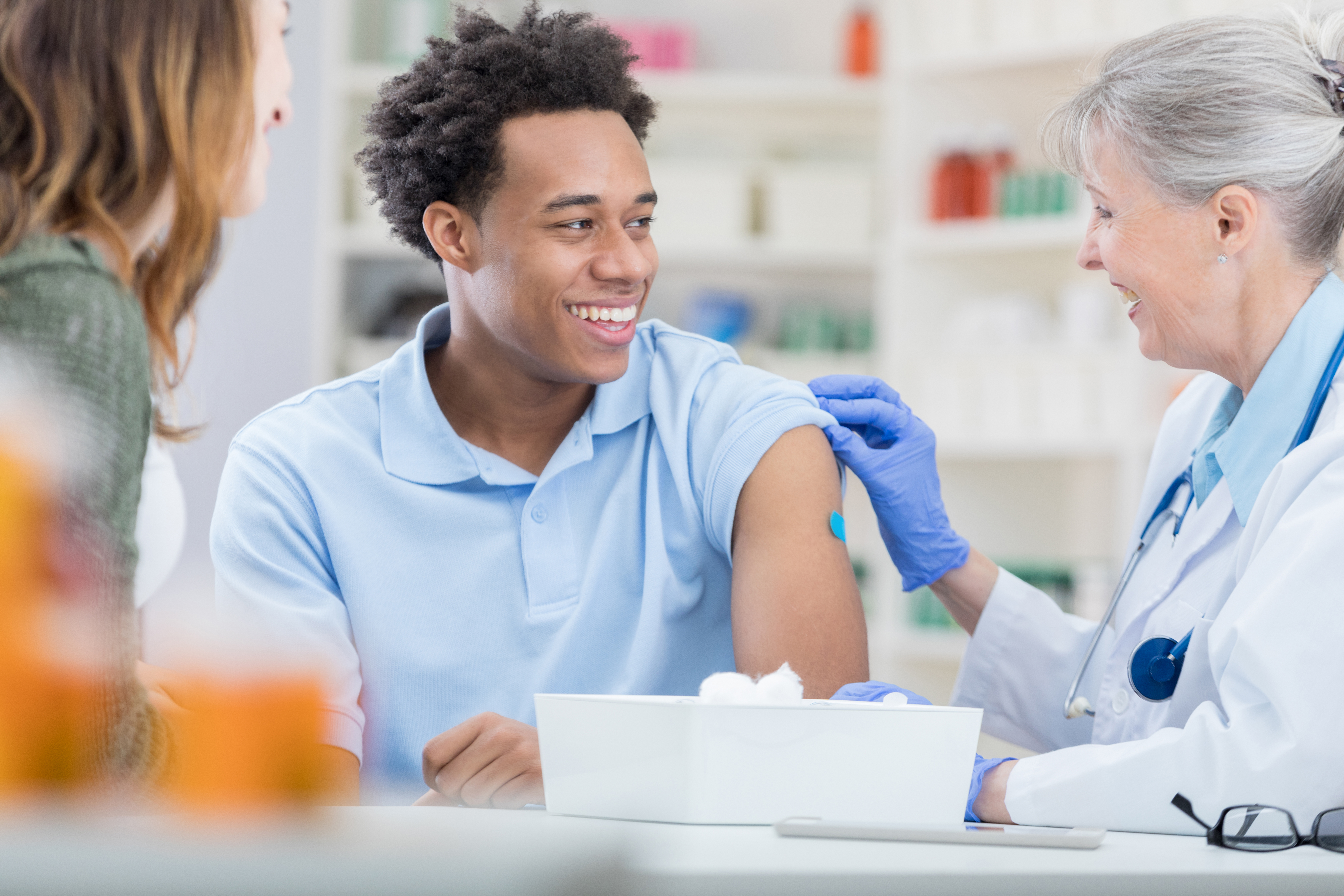 Male recieving a band-aid on arm after a flu shot