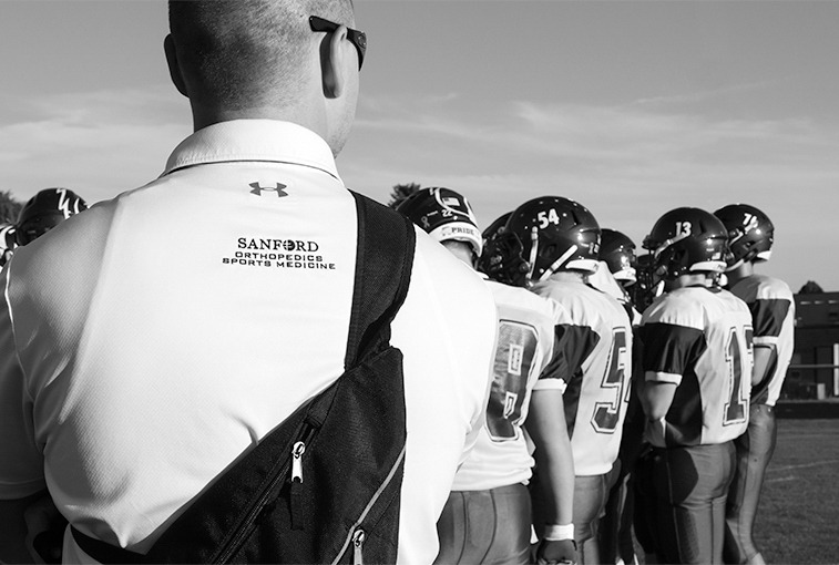 SLIDE SHOW (1/24): Sanford Health athletic trainer Dan Hawley, who works with athletes at Canton High School, watches the C-Hawks huddle up before game time versus Sioux Falls Christian on Sept. 7, 2018, in Canton, S.D.