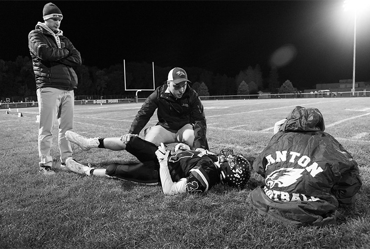 Hawley stretches out a muscle on Zander Elling during halftime on Sept. 28, in an attempt to prevent injuries.
