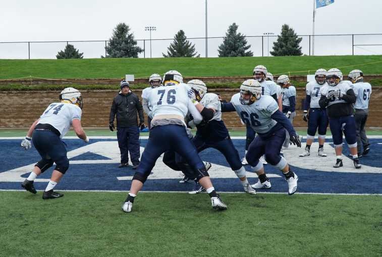Jerry Olszewski, head football coach for Augustana, oversees an offensive line drill during practice.