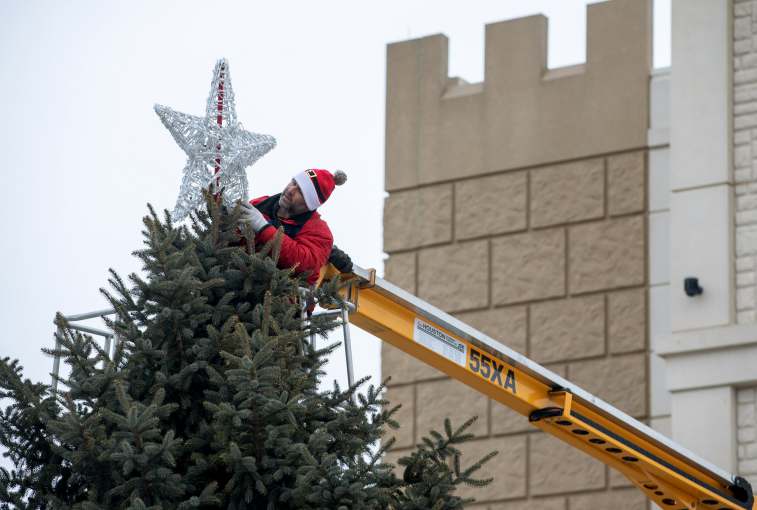Rod Hunter affixes the star to the tree outside the Sanford Children's Hospital.