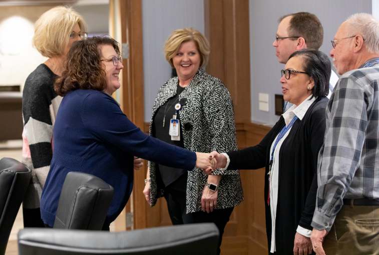 Susan Jarvis shakes hands with Accreditation Council for Pharmacy Education site visit reviewers. To her left are fellow Sanford Health leaders Nancy Demarais and Becky Moch.