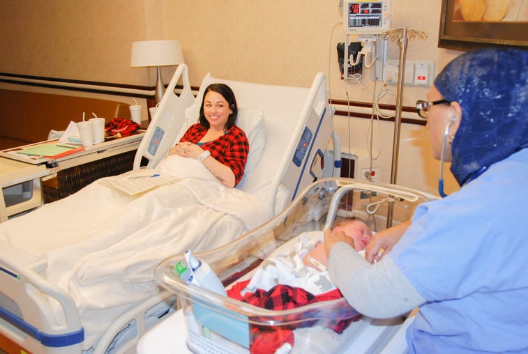 Eskedar Yimer, RN, visits the room of Danielle Svartoien and her newborn, Thomas, in Sanford Health's Birth Place.