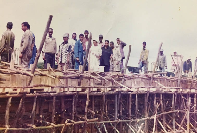 A bridge that Eskedar Yimer helped with in Ethiopia. She is standing, with a hat on, between the first and second poles from the left.