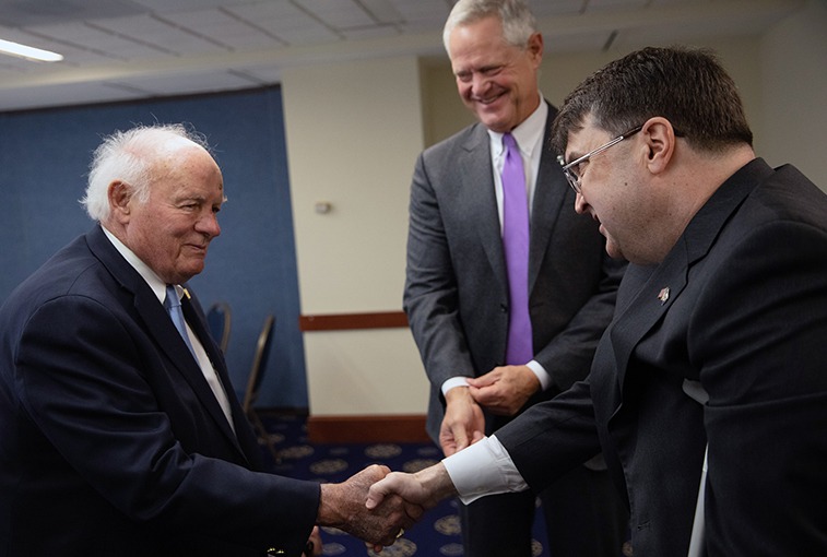 partnership helps veterans' care: Denny Sanford shaking hands with a man as Kelby Krabbenhoft looks on