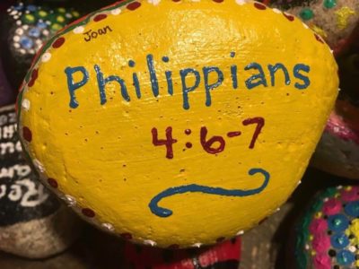 Yellow painted rock that says 'Philippians 4:6-7'