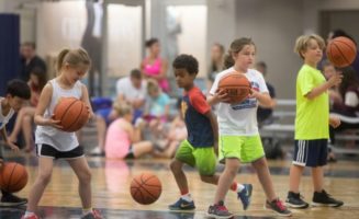 boys and girls bouncing basketballs
