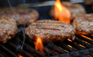 Hamburgers being flame broiled on the gas grill