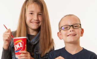 A girl and a boy eat DQ Blizzards for Miracle Treat Day, benefitting Children's Miracle Hospitals and Sanford Children's.