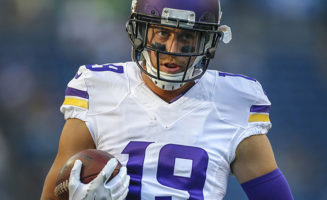 Adam Thielen carries the football in a Minnesota Vikings uniform