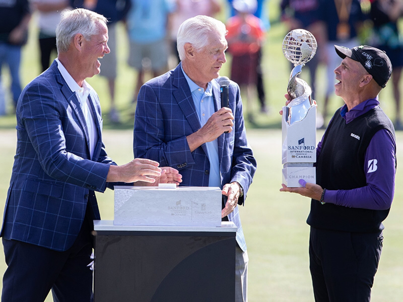 Sanford Health president and CEO Kelby Krabbenhoft (left) and PGA Tour champion Andy North (center) present Rocco Mediate with the Sanford International trophy on Sunday.