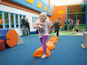 A girl runs through an obstacle course in a colorful room designed by Sanford fit.