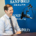 Steven Powell smiling in front of podcast microphone