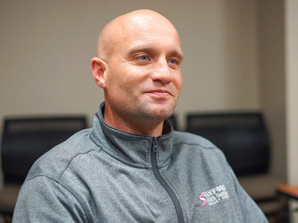 Doctor Jesse Dirksen sits in an upright posture, smiling during an interview