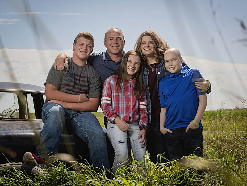 A family portrait of the Ericksons, including Ethan Erickson, standing outside in a field.