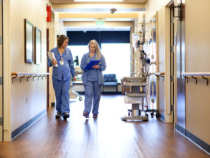 A healthy work environment fights doctor burnout. Clinicians walk down an Aberdeen medical center hallway.