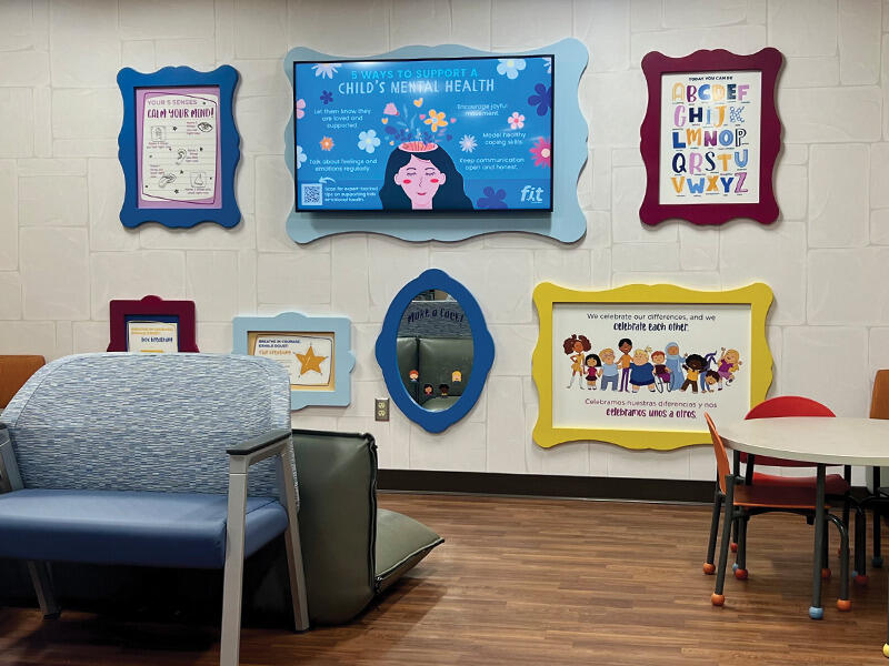 Children's clinic waiting room with colorful art and a "make a face" mirror in wavy frames.