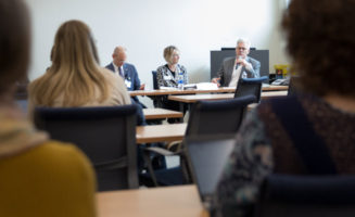 Leaders of Sanford Health and Good Samaritan Society meet around a conference table to discuss coronavirus in long-term care.