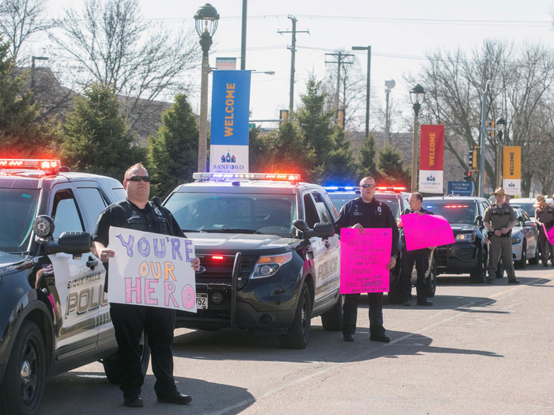 Police and other first responders line up around the children's hospital with handmade signs and messages for the patients. (Photo by Jay Pickthorn, Sanford Health)
