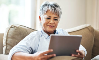 A senior woman using a tablet at home
