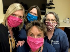 Alicia Haviland and three co-workers model their handmade cloth face masks.