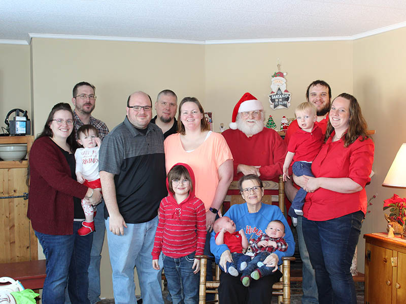 Brenda Russ poses with children and grandchildren and Santa dressed up for Christmas