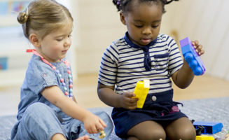 Two toddlers share toys