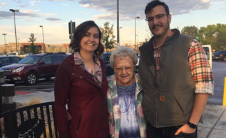 Alice Poulos stands between two grown grandchildren outside