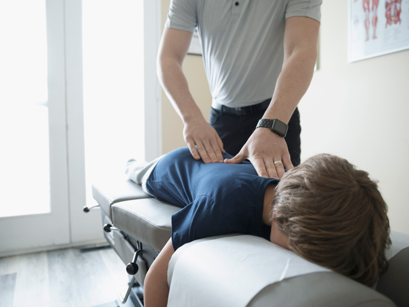 A boy receives chiropractic treatment.