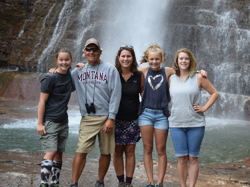 Berg family of five poses in front of a waterfall.