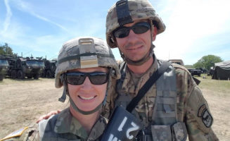 Two Veterans pose for a photo in their uniforms.