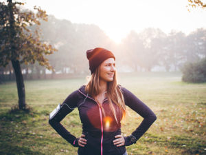 Runner in stocking cap and sweatshirt pauses on a sunny fall day.