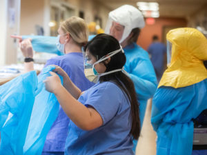 Four Sanford Health nurses don PPE in the hallway of a COVID-19 unit.