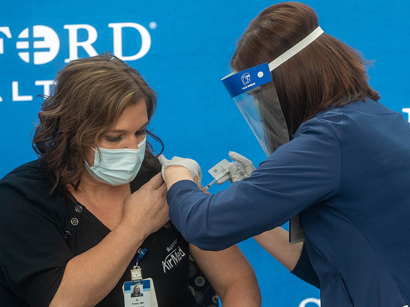 SLIDE SHOW (4/5): A Sanford AirMed crew member receives one of the first COVID-19 vaccinations at Sanford Imagenetics in Sioux Falls, South Dakota. (Photo by Jay Pickthorn, Sanford Health)