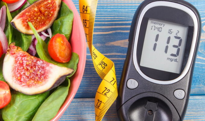 Fruit and vegetable salad, tape measure, and glucometer with result of measurement sugar level.
