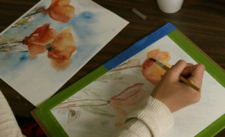 artist paints flowers in creative coping class
