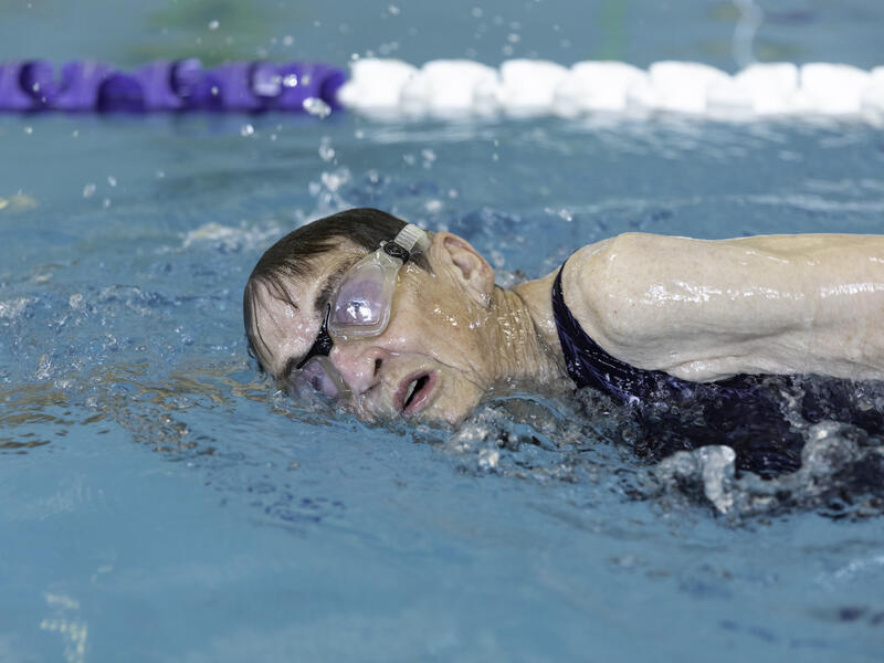 A senior woman in goggles takes a breath as she swims in a lap pool near Good Samaritan Society.