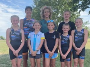 Coach Kathy Grady poses with youth triathletes after competition.