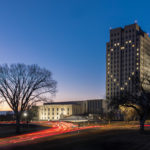 The tower of the North Dakota state capitol at sunset. Its windows are lit up in the shape of a heart.