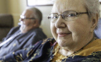 Closeup of softly smiling senior woman holding hands with her partner at the Good Samaritan Society.